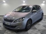 La voiture argentée est garée dans le showroom, sur le sol à damier.