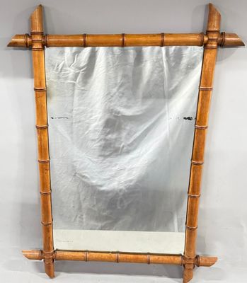 a mirror with a bamboo frame hanging on a wall