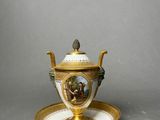 a gold and white cup and saucer on a saucer