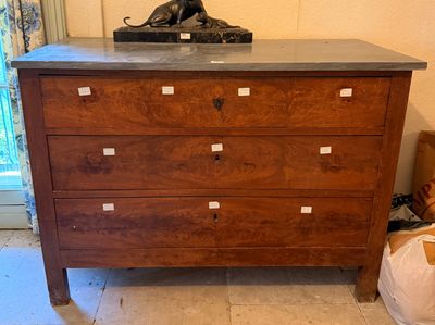 une commode en bois avec un plateau en marbre surmontée d'une statue de lion