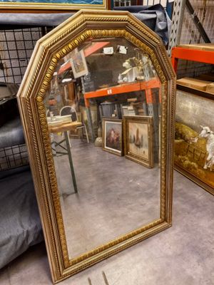 un miroir posé par terre à côté d'autres objets
