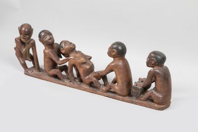 une figurine en bois représentant trois hommes assis sur un banc