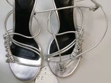 the silver shoes are on a white table with a price tag