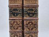 deux vieux livres posés l'un sur l'autre sur une table