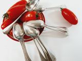 a bowl of spoons and spoons with tomatoes in it