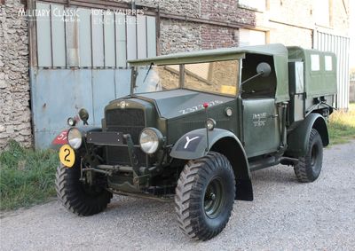 un vieux camion militaire garé devant un immeuble