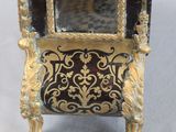 a gold and black clock with a mirror on top of it
