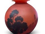 a red vase with a picture of a tree on it
