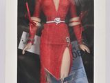 La poupée Barbie se trouve dans une boîte blanche ; elle porte une robe rouge et des chaussures rouges.