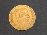 a close up of a gold coin on a black surface