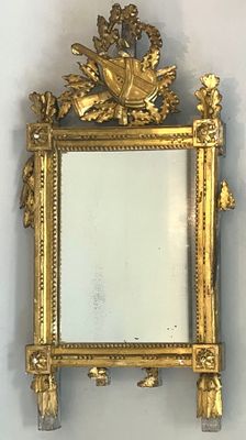 un miroir avec un cadre doré sur le mur