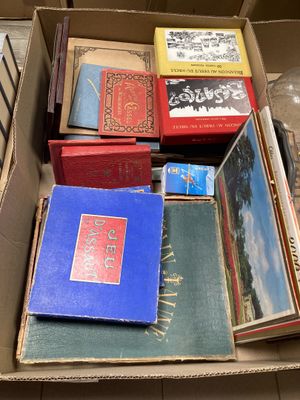 de nombreux livres dans une boîte posée par terre
