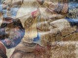 a tapestry with a picture of a man riding a horse