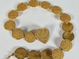 gold plated necklace and bracelet set on a white surface