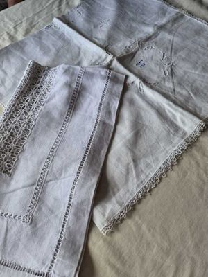 trois draps sur un lit recouvert d'une couverture blanche