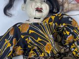 a doll that is laying on the ground with a hat