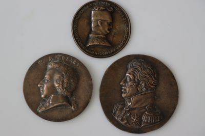 trois médaillons en bronze représentant deux hommes et une femme