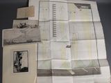 some old maps are laying on a table next to a black and white photo