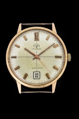 a close up of a gold wrist watch on a black background
