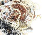 a pile of assorted beads and beads on a white surface