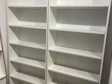 une bibliothèque blanche dans un coin de la pièce