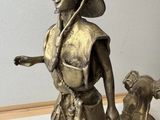 a bronze statue of a woman with a dog on a surfboard