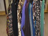 a lot of clothes hanging on a rack in a room