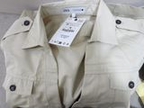 a white shirt with a tag on it sitting on a couch