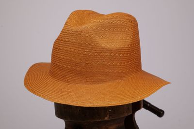 un chapeau marron posé sur un porte-chapeaux
