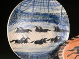 une assiette sur laquelle est représentée une image de chevaux au galop