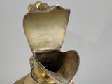 a gold vase on a white surface with a white background