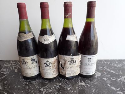 four bottles of wine are lined up on a table