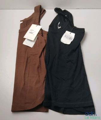 deux robes pour femmes, encore étiquetées, posées sur une table