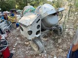 une bétonnière qui est posée par terre