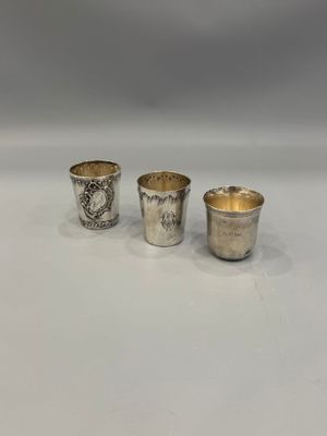 three silver cups sitting on top of a table next to each other