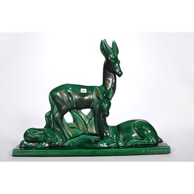 une image représentant une statue d'un cerf et d'un chien sur un socle vert