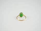 a gold ring with a green stone in the middle