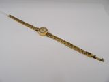 a close up of a gold wrist watch on a white surface