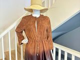 un mannequin portant une robe marron et un chapeau, exposé