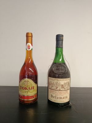 two bottles of alcohol sitting on a table next to each other