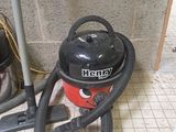 a vacuum that is sitting on the floor next to a trash can