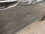 a silver car parked in a parking lot with other cars