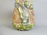 un vase orné d'une grenouille, posé sur une table