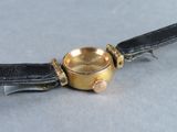 a watch that is sitting on a black leather strap
