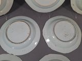 six white plates with gold rims are arranged on a table