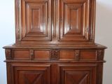 a wooden cabinet with two doors on top of it