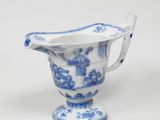un vase bleu et blanc muni d'une anse, sur un fond blanc