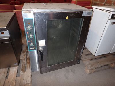 a small oven sitting on a pallet in a room