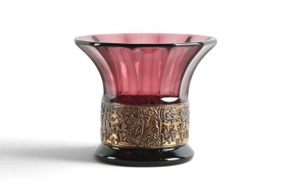 un vase en verre rose bordé d'or, posé sur une surface blanche