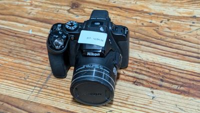 a camera sitting on a wooden table with a sticker on it